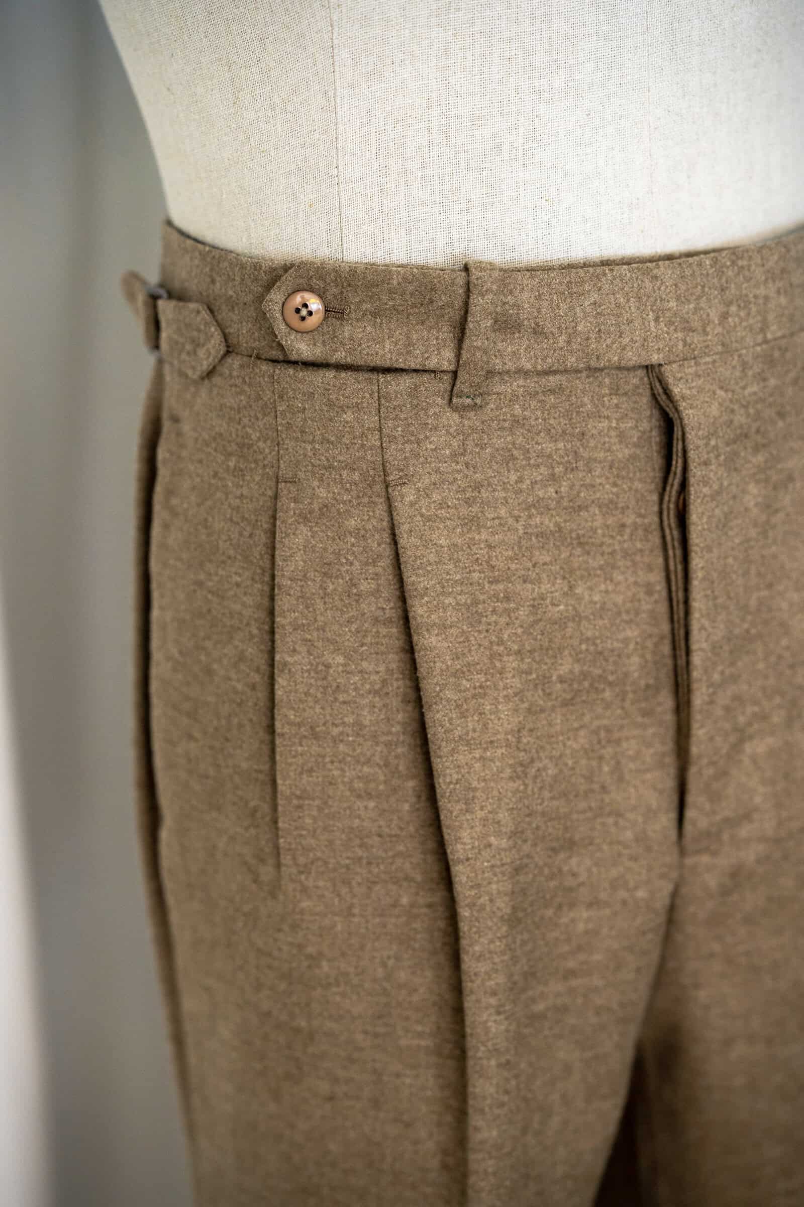 Hochgeschnittene Maßhose mit Bundfalten und seitlichem Versteller
