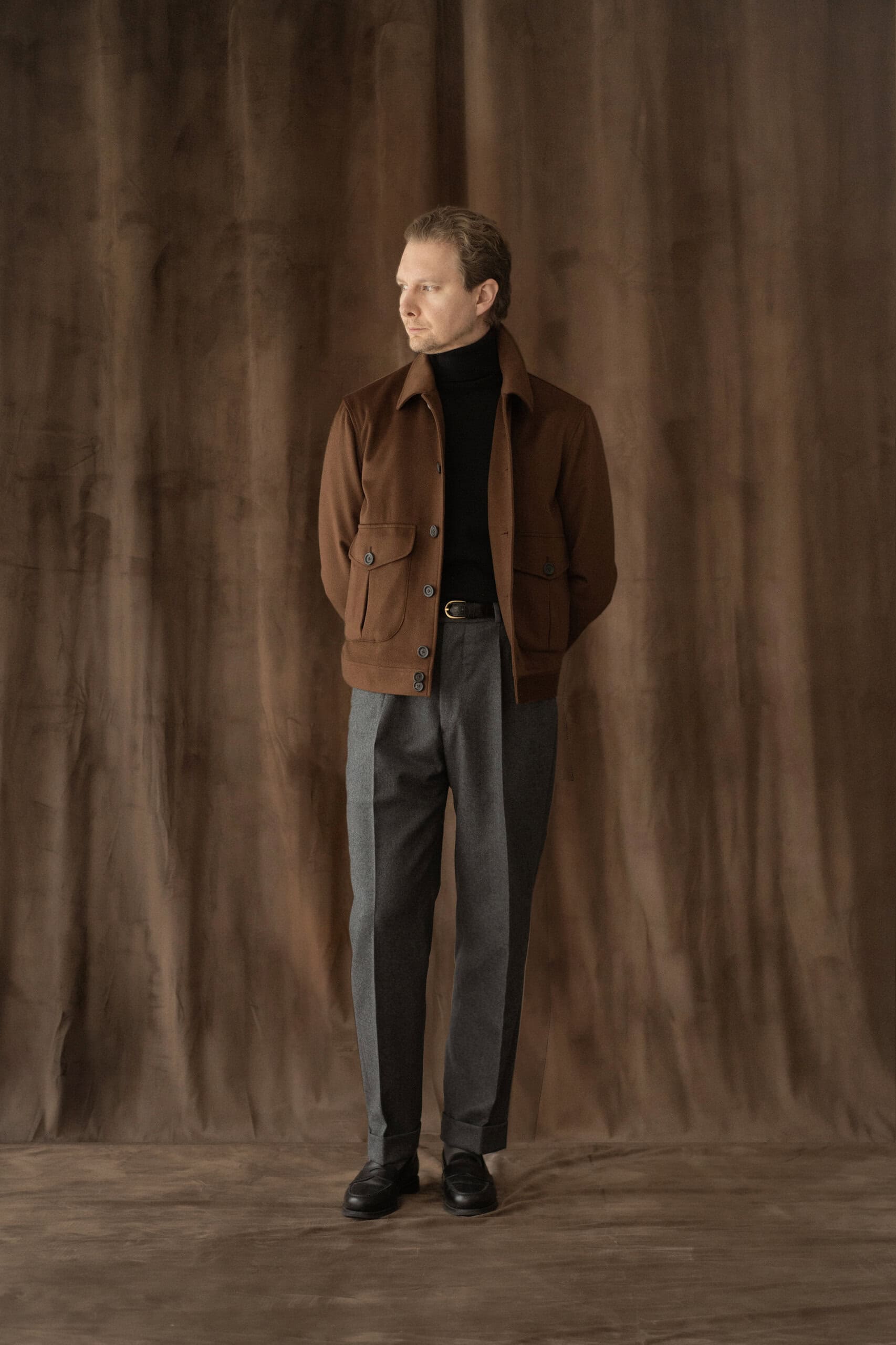 Blouson aus braunem Kaschmir mit schwarzem Rollkragenpullover und grauer Hose