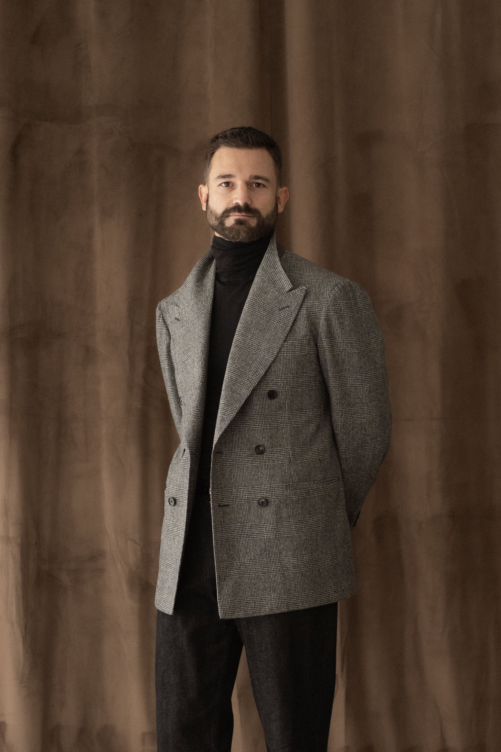 Grau gemusterter Zweireiher mit schwarzem Rollkragenpullover und schwarzen Jeans